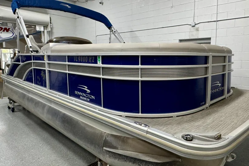 Slide: The Image of 2020 Bennington SXP 23 SSBXP pontoon boat with blue and silver exterior in a showroom. - 1