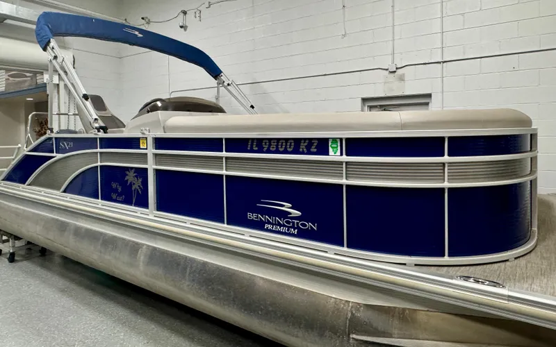 Slide: The Image of 2020 Bennington SXP 23 SSBXP pontoon boat with blue and silver design in a showroom. - 10