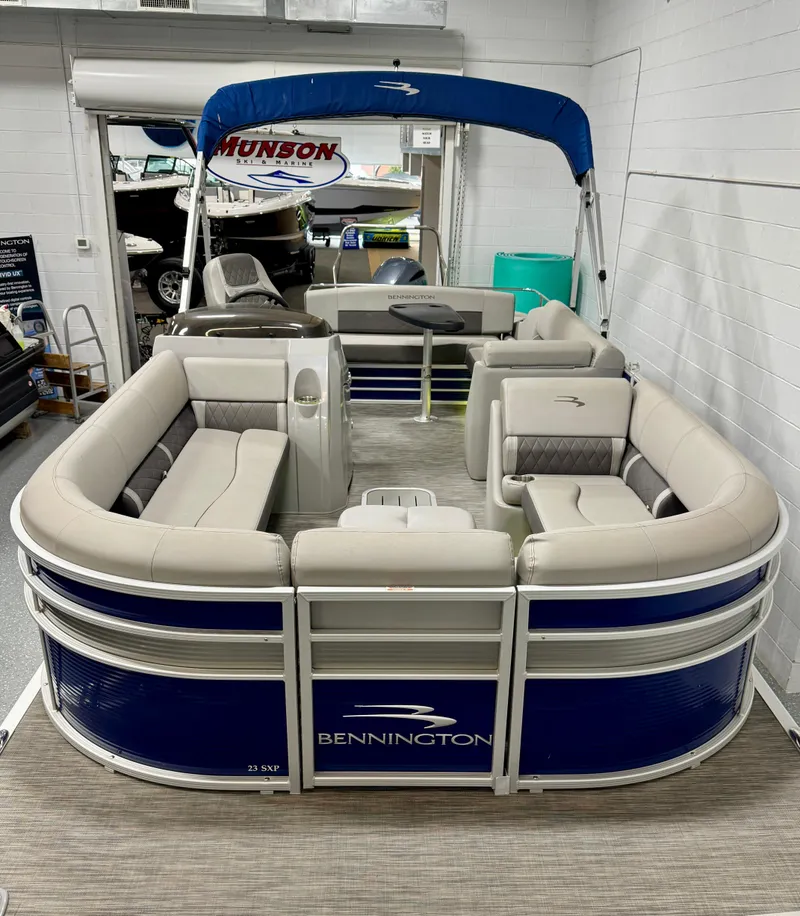 Slide: The Image of 2020 Bennington SXP 23 SSBXP pontoon boat with blue and beige seating in showroom. - 2