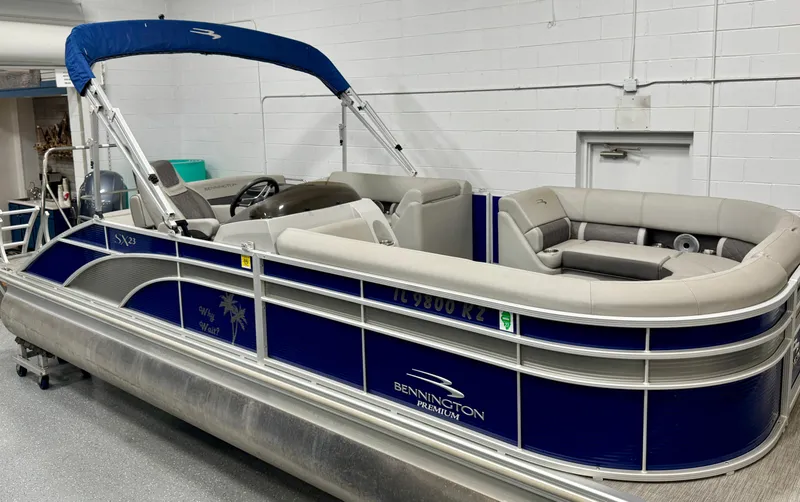 Slide: The Image of 2020 Bennington SXP 23 SSBXP pontoon boat with blue and silver design in showroom. - 6