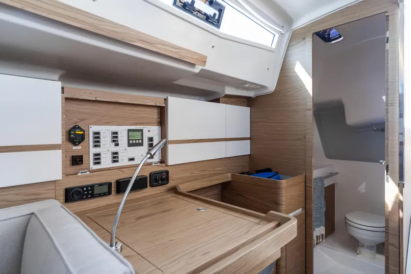 Slide: The Image of Interior of 2017 Elan E4 yacht featuring navigation controls and compact bathroom. - 16