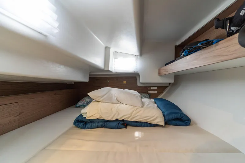 Slide: The Image of Cozy cabin interior of 2017 Elan E4 yacht with bedding and wooden accents. - 18