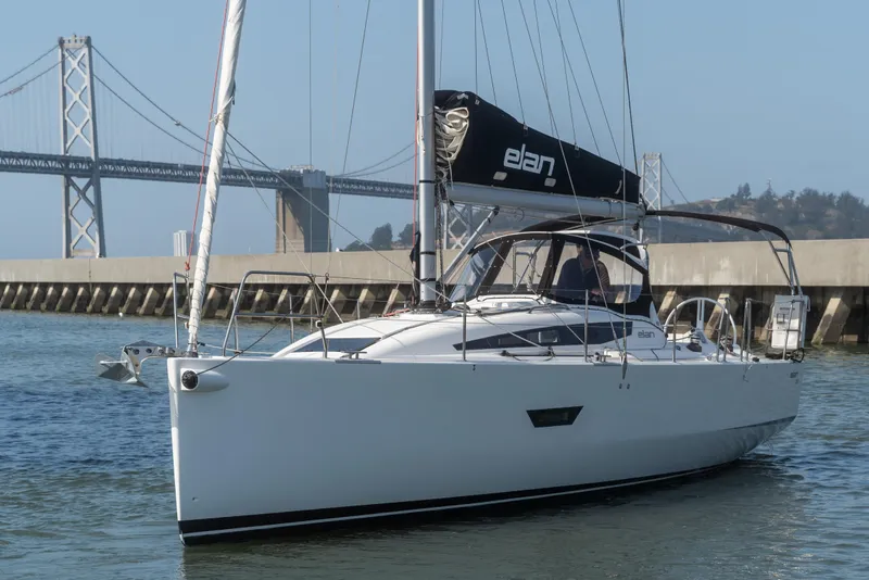 Slide: The Image of 2017 Elan E4 sailboat on water near a bridge, showcasing sleek design and modern features. - 2