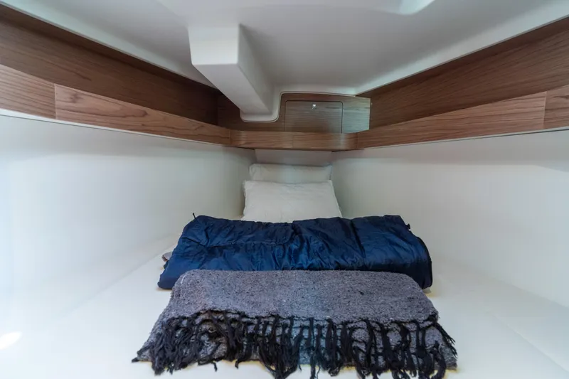 Slide: The Image of Cozy cabin interior of 2017 Elan E4 yacht with bedding and wooden accents. - 24