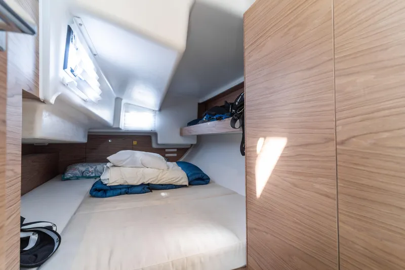 Slide: The Image of Cozy cabin interior of 2017 Elan E4 yacht with wooden finish and bedding. - 27