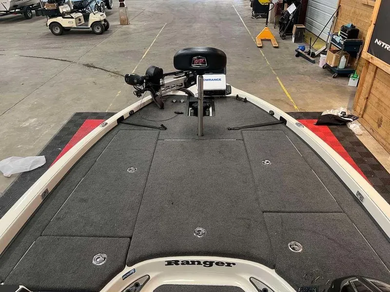 Slide: The Image of 2018 Ranger Z521C boat interior with fishing deck and seat in a garage setting. - 6