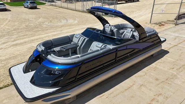 Slide: The Image of 2024 Bennington 25 QFBWA pontoon boat with sleek design and luxurious seating on a sunny day. - 1