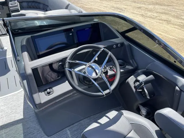 Slide: The Image of 2024 Bennington 25 QFBWA boat dashboard with steering wheel and modern controls. - 10