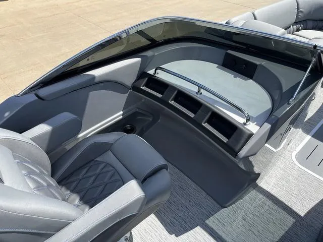 Slide: The Image of 2024 Bennington 25 QFBWA boat interior with sleek gray seating and modern dashboard design. - 12