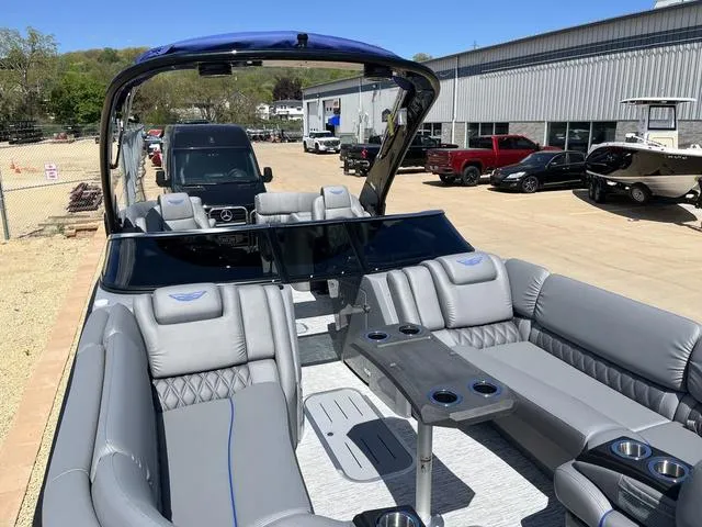 Slide: The Image of 2024 Bennington 25 QFBWA pontoon boat with luxurious seating and modern design in a marina setting. - 17