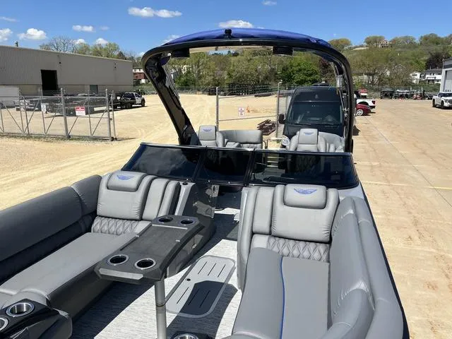 Slide: The Image of 2024 Bennington 25 QFBWA pontoon boat with luxurious seating and sleek design on a sunny day. - 19