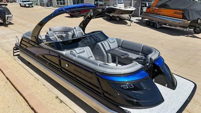 Slide: The Image of 2024 Bennington 25 QFBWA pontoon boat with sleek design and luxurious seating. - 2