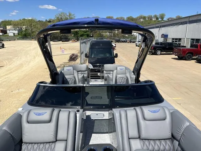 Slide: The Image of 2024 Bennington 25 QFBWA pontoon boat with luxurious seating and sleek design, parked outdoors. - 20