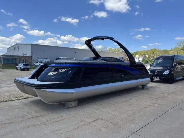 Slide: The Image of 2024 Bennington 25 QFBWA pontoon boat parked outdoors on a sunny day. - 5
