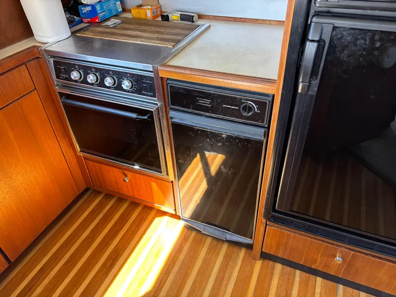 Slide: The Image of 1994 Bayliner 4700 yacht kitchen with stove, dishwasher, and wood flooring. - 15