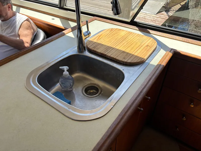Slide: The Image of Kitchen sink area on a 1994 Bayliner 4700 yacht with cutting board and soap dispenser. - 17
