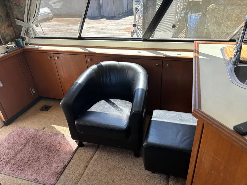 Slide: The Image of Interior of 1994 Bayliner 4700 yacht with black leather chair and wooden cabinets. - 20