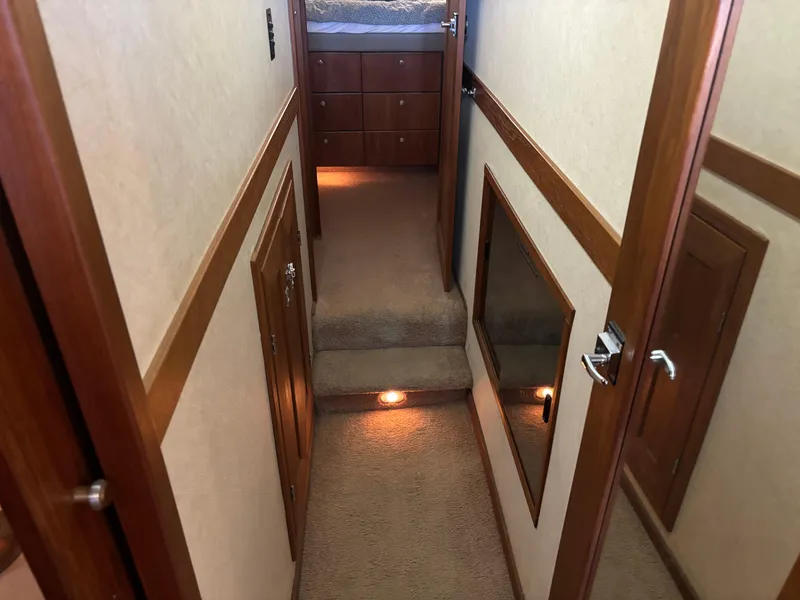 Slide: The Image of Interior hallway of a 1994 Bayliner 4700 yacht with carpeted steps and wooden accents. - 21