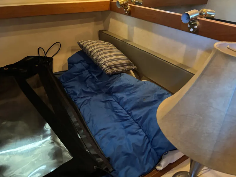 Slide: The Image of Cozy cabin interior of 1994 Bayliner 4700 with blue sleeping bag and striped pillow. - 23