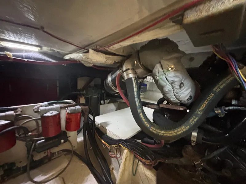 Slide: The Image of Engine room of a 1994 Bayliner 4700, showcasing hoses and mechanical components. - 32