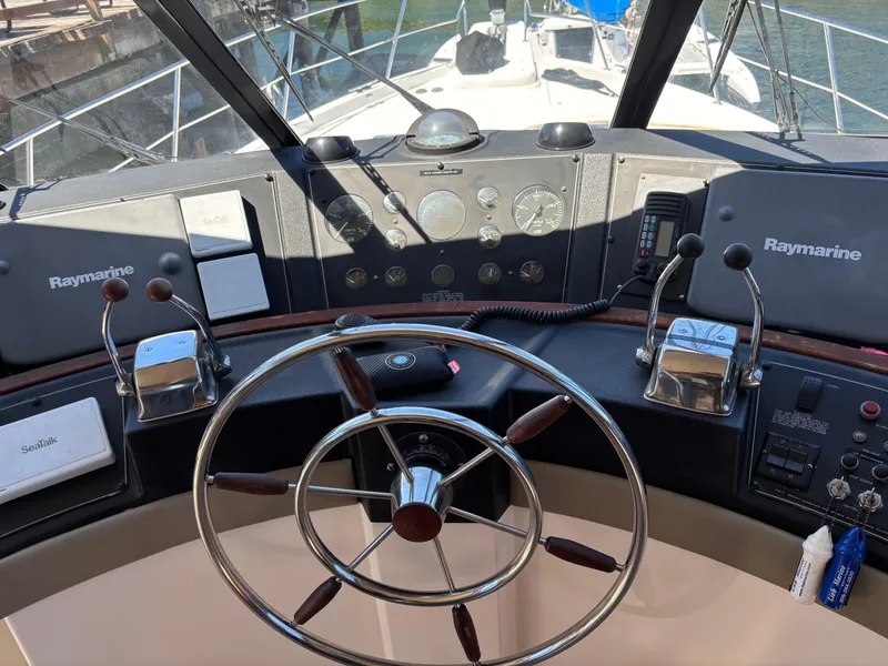 Slide: The Image of 1994 Bayliner 4700 helm with steering wheel, Raymarine equipment, and navigational controls. - 7
