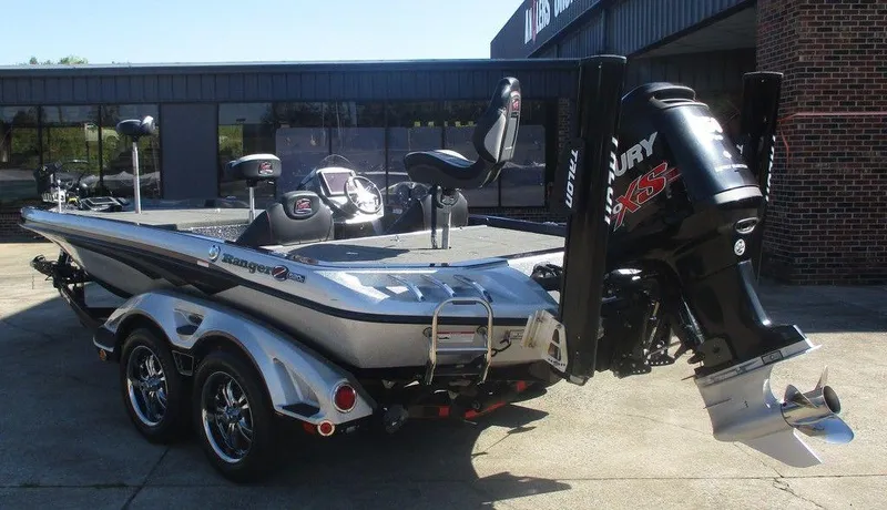 Slide: The Image of 2018 Ranger Z520C boat with Mercury engine, parked on a trailer outside a building. - 2