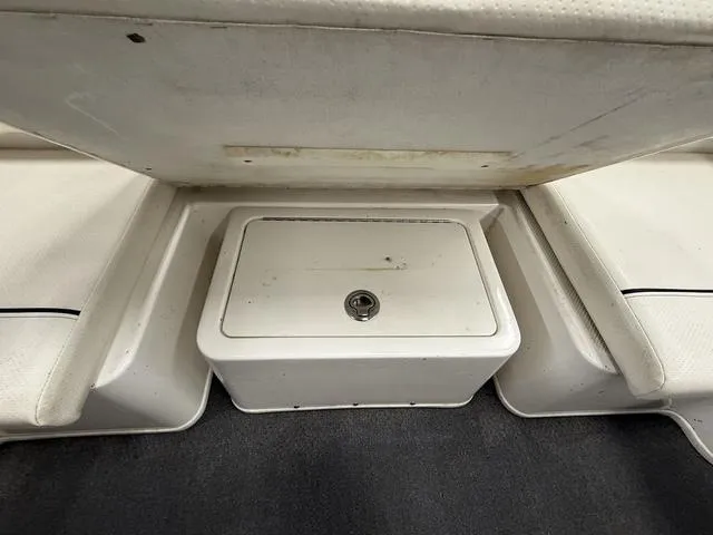 Slide: The Image of 2012 Bayliner 170SF boat storage compartment with white cushioned seating and carpeted flooring. - 5