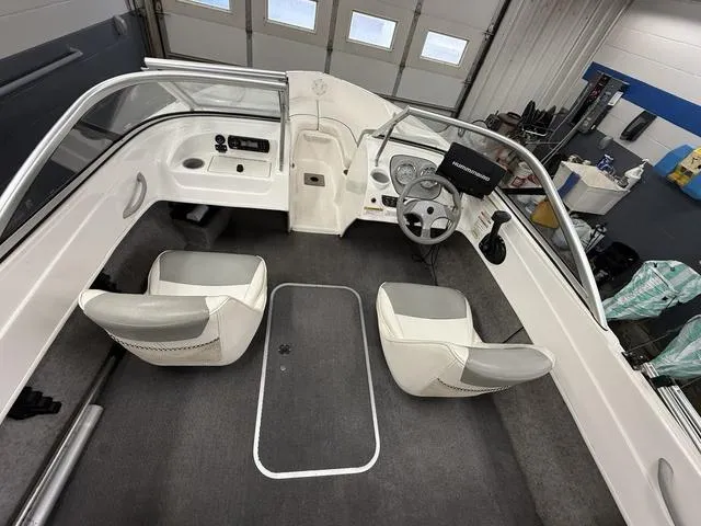 Slide: The Image of 2012 Bayliner 170SF boat interior with dual seats and steering console in a garage setting. - 7