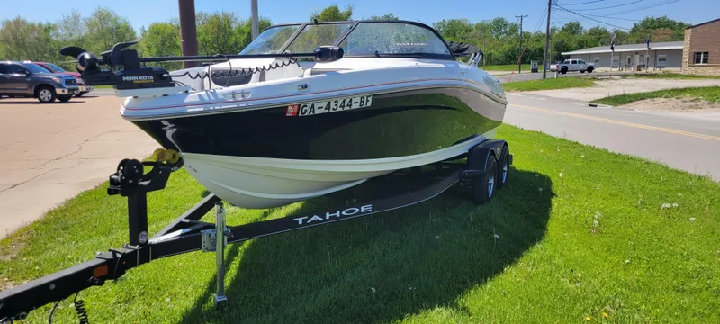 Slide: The Image of 2021 Bass Tracker TAHOE 550TF boat on trailer, parked on grass. - 16