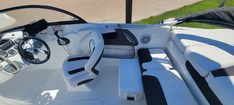 Slide: The Image of 2021 Bass Tracker TAHOE 550TF boat interior with white seating and steering wheel. - 34