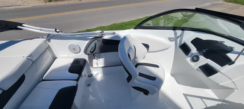 Slide: The Image of 2021 Bass Tracker TAHOE 550TF boat interior with white and black seating, steering wheel, and dashboard. - 35