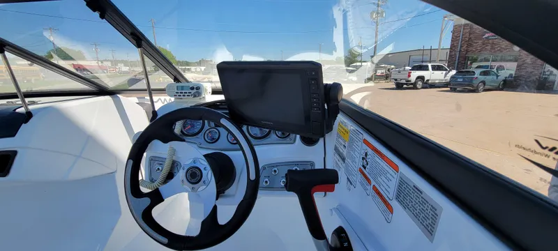 Slide: The Image of 2021 Bass Tracker TAHOE 550TF boat dashboard with steering wheel and navigation display. - 4