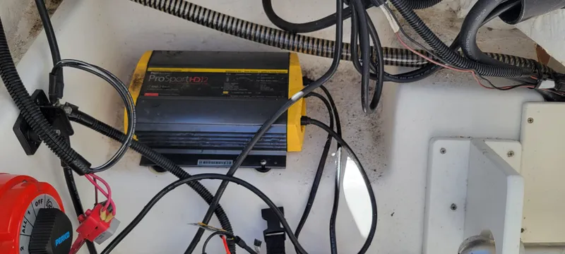 Slide: The Image of Battery charger and wiring inside a 2021 Bass Tracker TAHOE 550TF boat. - 9