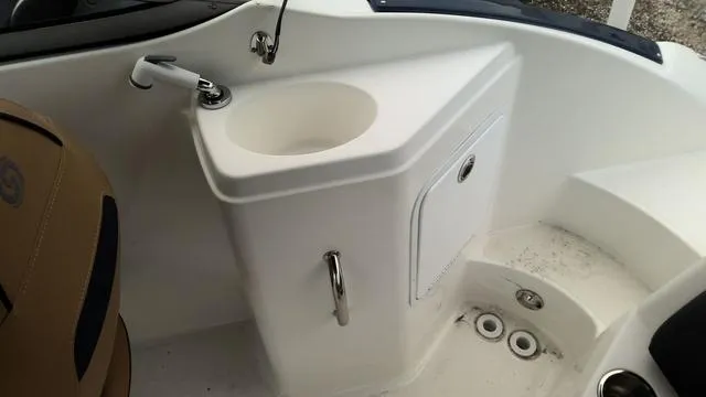Slide: The Image of 2022 Hurricane Sundeck 2200 OB boat interior with sink and storage compartment. - 9