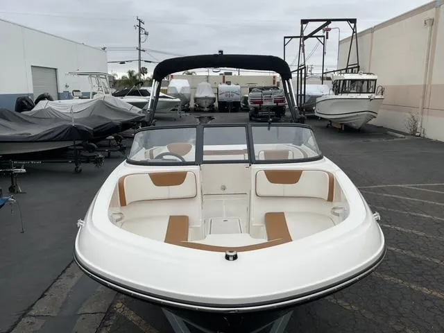 Slide: The Image of 2020 Bayliner VR4 Bowrider I/O in a boatyard, showcasing sleek design and spacious seating. - 10