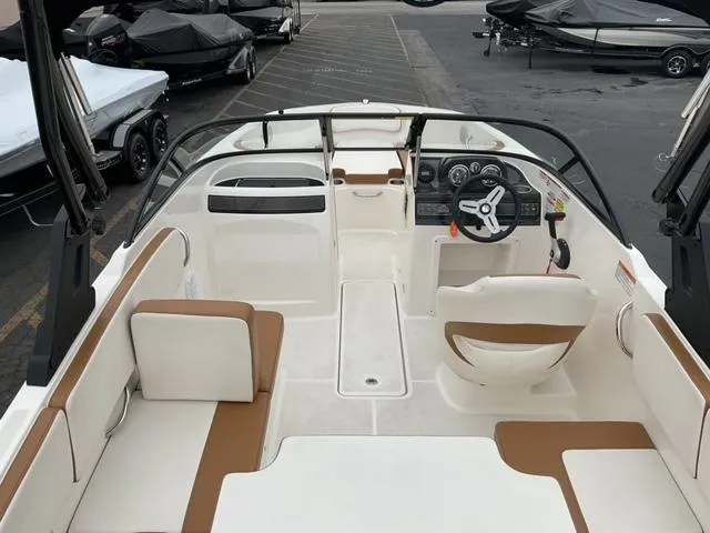 Slide: The Image of 2020 Bayliner VR4 Bowrider I/O interior with seating and steering wheel, docked in a marina. - 15