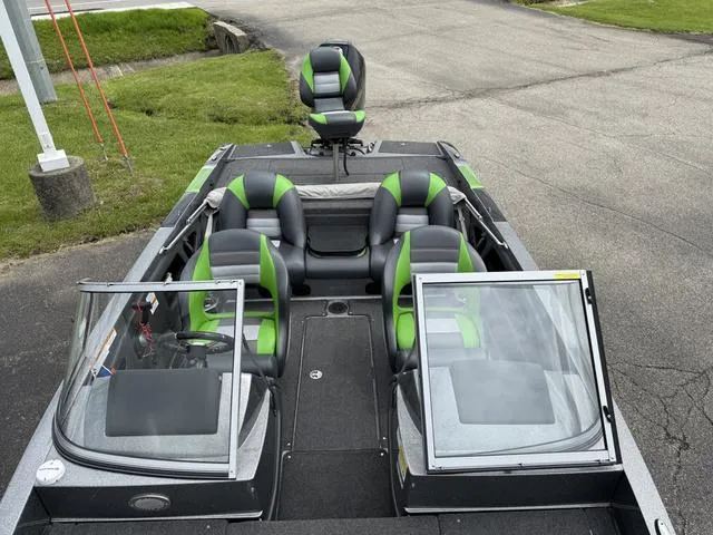 Slide: The Image of 2020 Ranger 212LS boat with green and black seating, parked on pavement. - 6