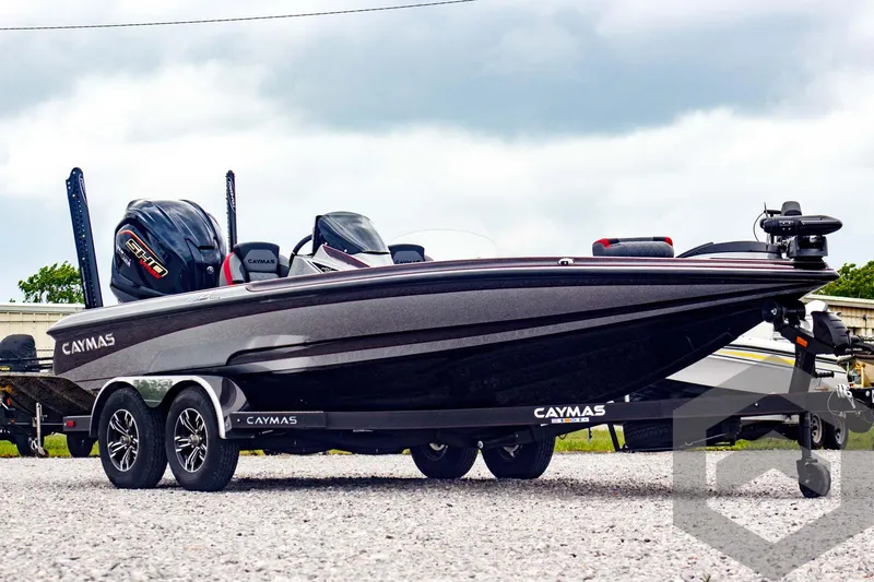 Slide: The Image of 2025 Caymas CX 21 PRO boat on trailer, sleek design, dual engines, parked outdoors. - 3