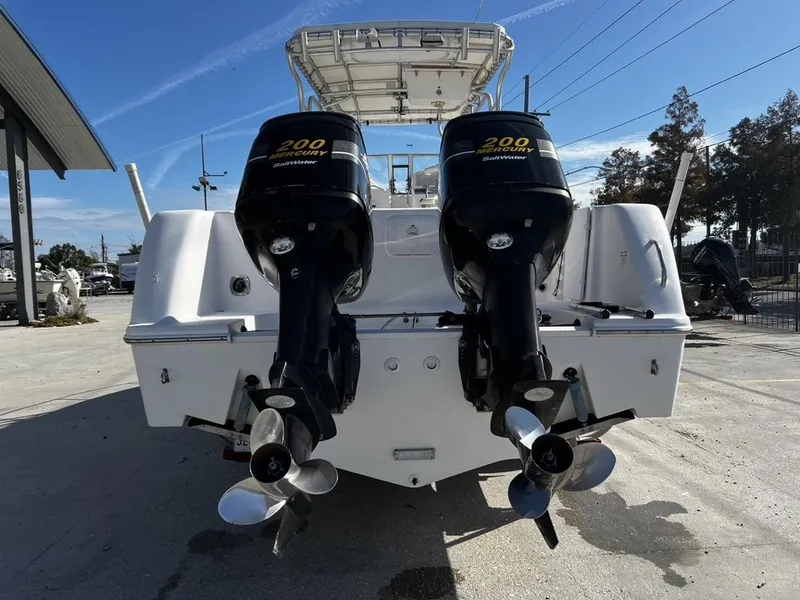 Slide: The Image of 2001 Pro-Line 27 Express boat with twin Mercury 200 outboard engines, docked outdoors. - 2