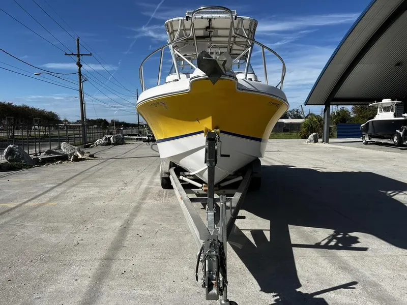 Slide: The Image of 2001 Pro-Line 27 Express boat with yellow hull on trailer, parked outdoors. - 4