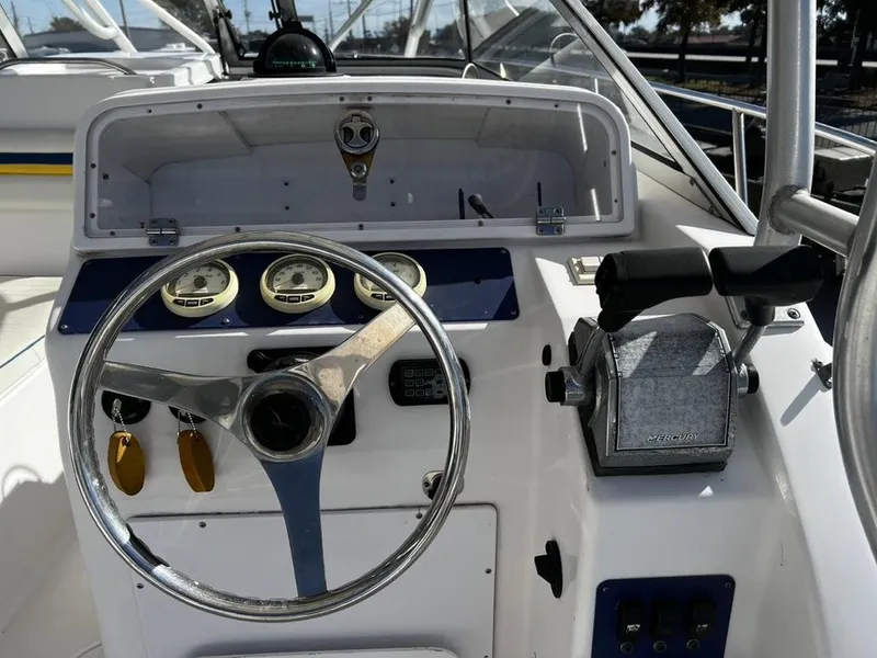 Slide: The Image of 2001 Pro-Line 27 Express boat dashboard with steering wheel and Mercury controls. - 8