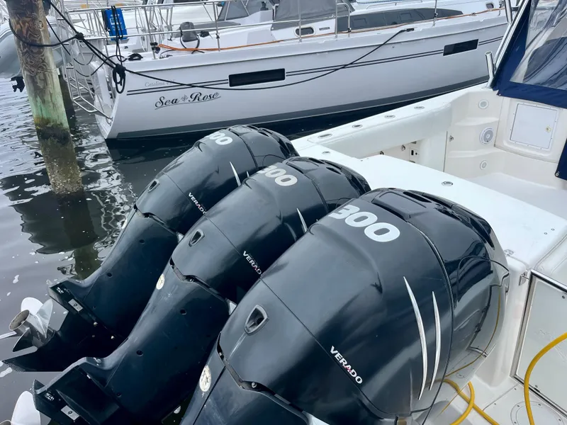 Slide: The Image of Three powerful outboard motors on a 2011 Fountain 38 Sportfish Cruiser docked at a marina. - 1