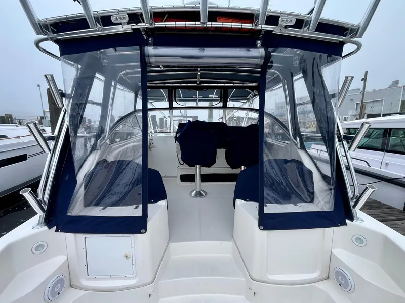 Slide: The Image of 2011 Fountain 38 Sportfish Cruiser with blue canopy, docked at marina. - 10