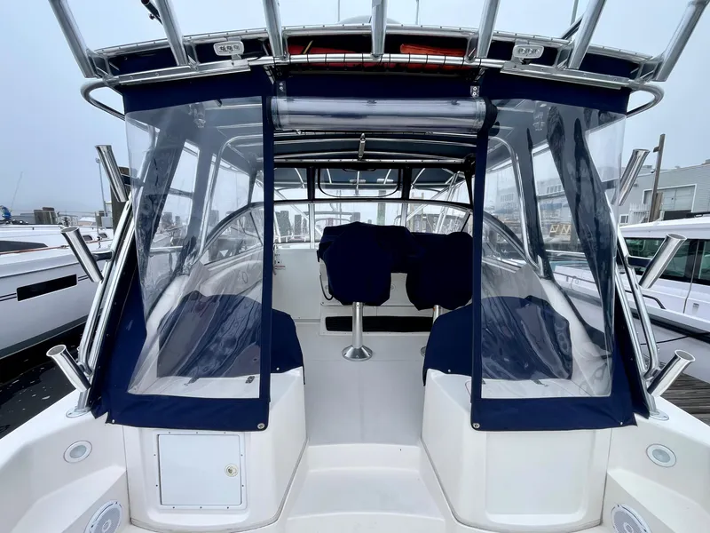 Slide: The Image of 2011 Fountain 38 Sportfish Cruiser with blue canopy and seating, docked at marina. - 11