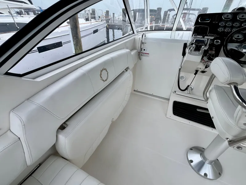 Slide: The Image of 2011 Fountain 38 Sportfish Cruiser cockpit with white seating and control panel. - 18