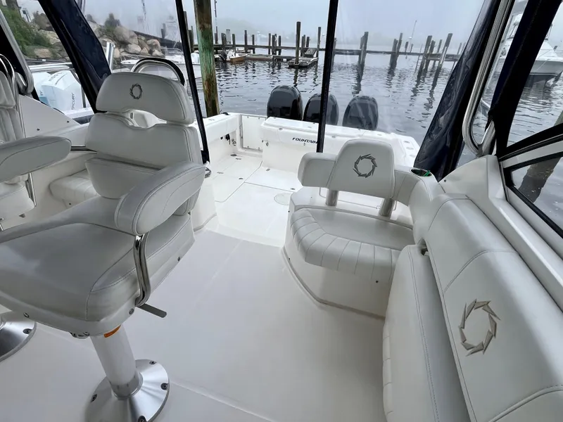 Slide: The Image of Interior of 2011 Fountain 38 Sportfish Cruiser with white seating and water view. - 21