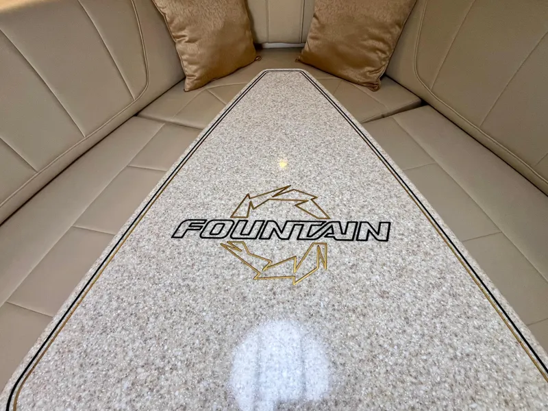 Slide: The Image of 2011 Fountain 38 Sportfish Cruiser interior with logo on beige seating. - 28