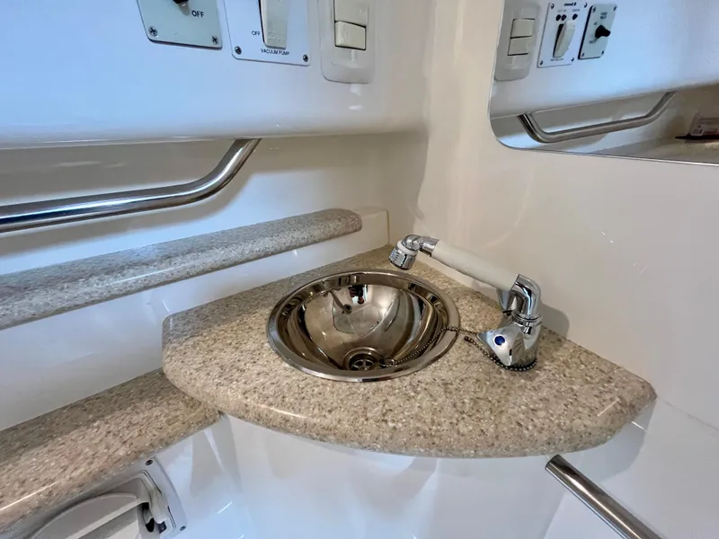 Slide: The Image of Compact sink area in 2011 Fountain 38 Sportfish Cruiser boat, featuring granite countertop and modern fixtures. - 33