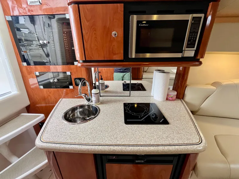 Slide: The Image of Compact kitchen area in a 2011 Fountain 38 Sportfish Cruiser with sink, stove, and microwave. - 39