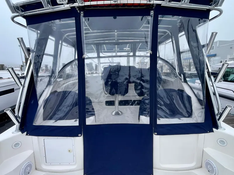 Slide: The Image of 2011 Fountain 38 Sportfish Cruiser with blue canvas enclosure and seating area. - 9